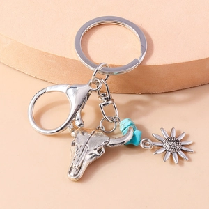 Detail of vintage bull skull keychain with turquoise beads and sunflower charm