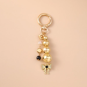 Detail of gold-tone keychain featuring beaded links and rhinestone bow heart charm