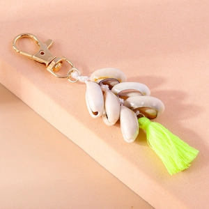 Detail of seashell keychain featuring white conches and a vibrant neon yellow tassel charm