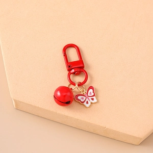 Detailed close-up of a red butterfly keychain with a matching bell and metal lobster clasp