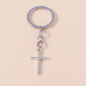 Detailed view of silver plated cross keychain with sparkling white rhinestones
