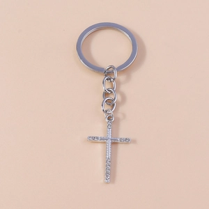 Detailed macro view of silver cross keychain with sparkling inlaid rhinestones and chain