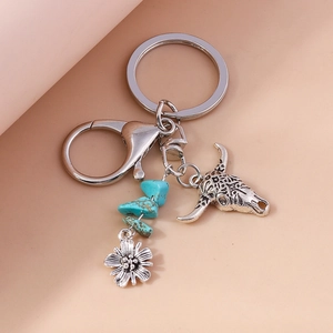 Detail of bohemian bull skull keychain with turquoise stones and floral metal charms
