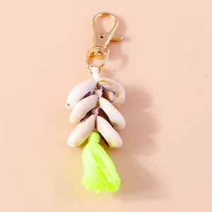 Detailed view of bohemian conch shell keychain with bright yellow fringe tassel