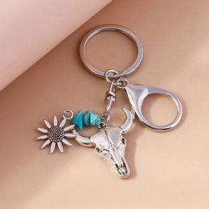Detailed close-up of retro bull skull keychain with sunflower charm and turquoise stones