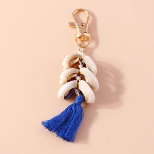 Detailed close-up of shell keychain featuring golden clasp and royal blue silk tassel