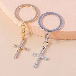 Detailed view of gold and silver cross keychains featuring sparkling rhinestone inlay