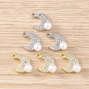 Détail de pendentifs en forme de lune avec strass et perles blanches pour bijoux artisanaux