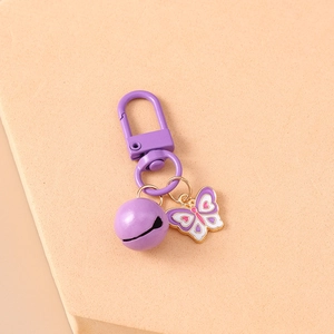 Detailed macro view of purple enamel butterfly keychain with bell and lobster clasp