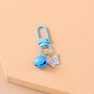 Close-up of sky blue enamel butterfly keychain with a matching bell and carabiner clip