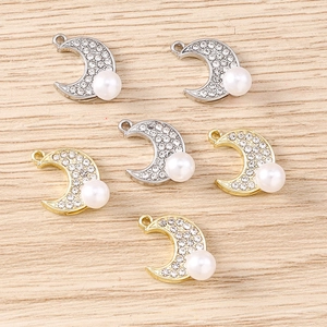 Détail de pendentifs lune baroques avec strass blancs et perles pour bijoux artisanaux
