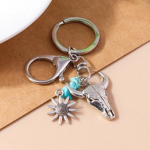 Detailed macro view of vintage silver bull skull and sunflower charms with turquoise stones