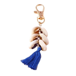 Golden keychain with natural white shells and deep blue tassels in bohemian style