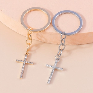 Detailed close-up of gold and silver cross keychains with sparkling rhinestones
