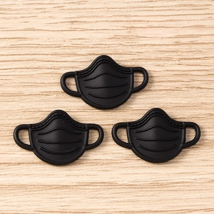 Detailed macro view of 3D black mask-shaped pendants for DIY jewelry and crafts