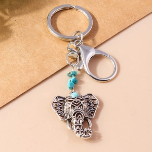 Detailed view of vintage silver elephant keychain with turquoise beads and intricate carving