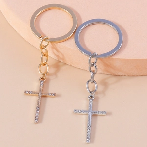 Detail of gold and silver Christian cross keychains with rhinestones on a round pedestal