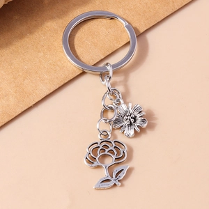 Detailed view of silver key ring with retro daisy and hollow rose flower charms