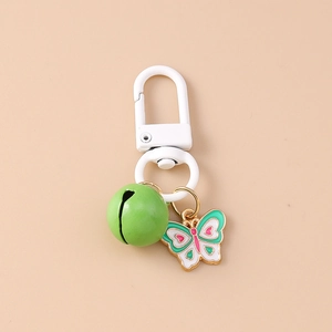 Detail of butterfly enamel keychain with green bell and white lobster clasp charm
