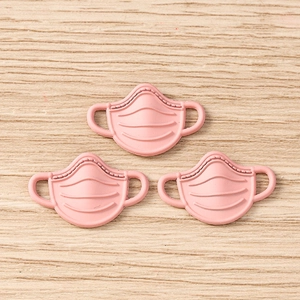 Detailed view of pink resin mask pendants for DIY jewelry and handicraft making
