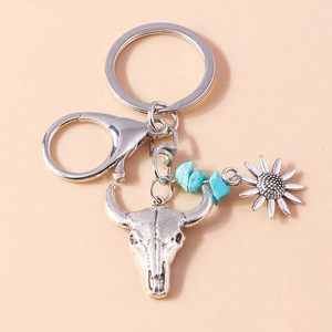 Macro detail of retro bull skull keychain with sunflower charm and turquoise stones