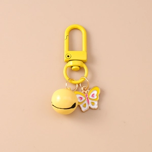 Detailed macro view of yellow butterfly enamel charm and bell on metal keychain