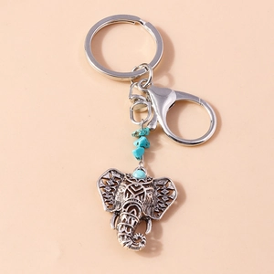 Detail view of retro silver elephant keychain with turquoise beads and boho ethnic patterns