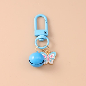 Detail view of a blue butterfly keychain with metal bell and enamel finish accents