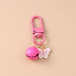Detailed view of pink butterfly enamel charm with heart detail and matching bell keychain