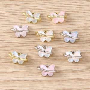 Détail de pendentifs papillon en résine colorée avec anneaux étoilés pour bijoux DIY
