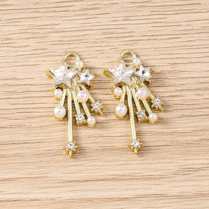 Macro detail of Y2K star pendants with rhinestones, pearls, and gold-plated metal tassels
