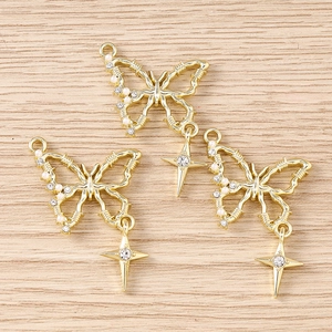 Detailed macro view of golden hollow butterfly pendants with pearls and rhinestones