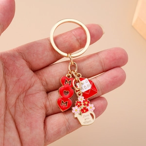 Detailed view of Mother's Day keychain with MOM heart, envelope, and floral watering can charm