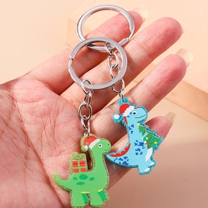 Detail of Christmas dinosaur keychains with festive hats and sparkling glitter finish
