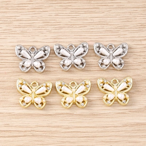 Macro detail of butterfly pendants featuring sparkling rhinestones and white pearls