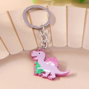 Close-up of purple acrylic dinosaur keychain with glitter and green Christmas tree pattern
