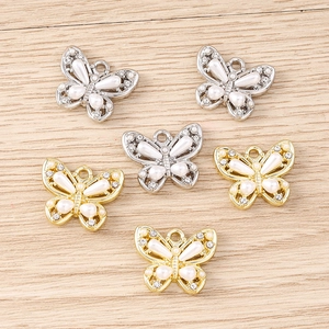Detailed macro view of five exquisite butterfly charms with faux pearls and rhinestones