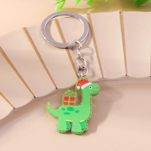 Detail of green glitter acrylic dinosaur keychain with red Christmas hat and silver ring