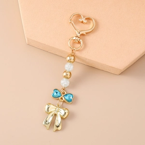 Porte-clés tendance cœur et nœud avec strass et perles sur un support orange