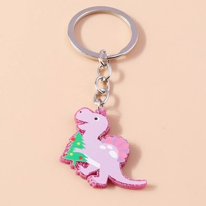 Macro detail of a purple acrylic dinosaur keychain with glitter and a Christmas tree