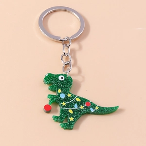 Macro detail of a sparkling green dinosaur keychain with colorful festive bulb decorations