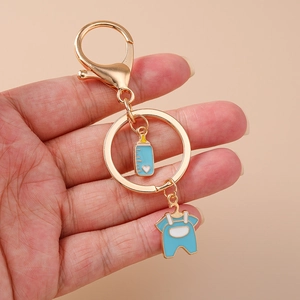 Close-up of baby theme keychain with blue enamel bottle and overalls on gold clasp