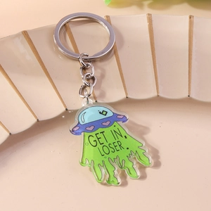 Close-up of a creative acrylic UFO keychain featuring a green light beam and funny text