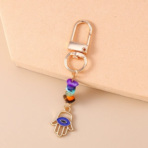 Detailed macro view of golden Hamsa Hand keychain with evil eye and colorful stones