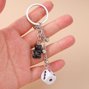 Fashionable keychain featuring a resin bear charm, dice pendant, and silver metal beads