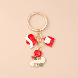 Close-up of gold Mom keychain with red heart, envelope and rose charms for Mother's Day