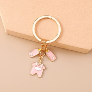 Pink baby bottle and romper charms on golden keychain for baby items and bags