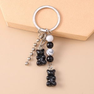 Detailed view of fashionable keychain with black resin bears and marble beads