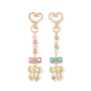 Porte-clés à nœud en cœur à la mode avec strass et perles sur fond blanc épuré
