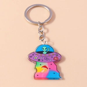 Detailed close-up of acrylic UFO keychain with alien pilot and rainbow mushroom graphics